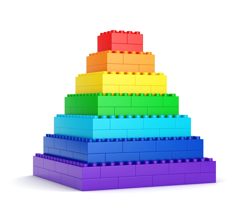 A tower constructed out of building blocks. It has multiple colors.